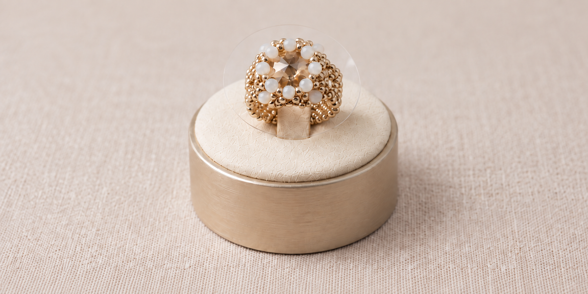 A silver-toned beaded ring with white faceted glass beads and a champagne-coloured stone, created by MiyuQi Designs.