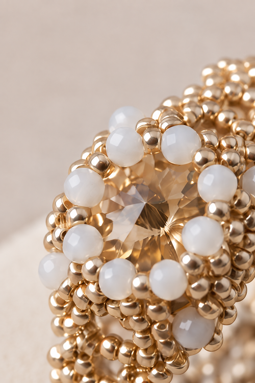 A silver-toned beaded ring with white faceted glass beads and a champagne-coloured stone, created by MiyuQi Designs.