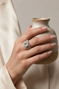 A silver-toned beaded ring with white faceted glass beads and a champagne-coloured stone, created by MiyuQi Designs.