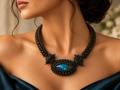 A statement necklace made of dark metallic beads and a central oval blue-green stone. Created by MiyuQi Designs
